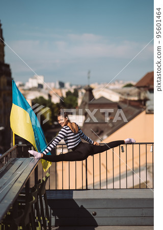 A young woman is doing twine on the roof of the house A young woman is doing twine on the roof of the house 95601464