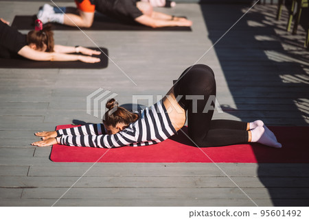 Yogi woman and diverse group of sporty people practicing yoga Yogi woman and diverse group of sporty people practicing yoga 95601492