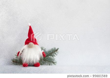 Christmas gnome in red hat with fir branch holiday card on light winter background 95601569