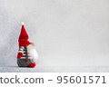 Christmas gnome in red hat side view holiday card on light winter background 95601571
