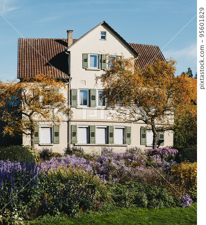 House with nice garden in fall. Flowers in the City Park of Bietigheim-Bissingen, Baden-Wuerttemberg, Germany, Europe. Autumn Park and house, nobody, bush and grenery House with nice garden in fall. Flowers in the City Park of Bietigheim-Bissingen, Baden-Wuerttemberg, Germany, Europe. Autumn Park and house, nobody, bush and grenery 95601829