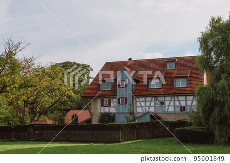 Traditional Rural House With Beautiful Exterior Facade Decor In Germany. German Old Construction House. Ancient European City. German National Architecture 95601849