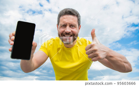 glad man presenting screen of smartphone with copy space glad man presenting screen of smartphone with copy space 95603666