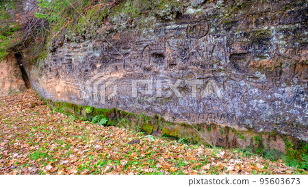 Natural cave in sandstone rock, former bank of Gauja river. Carved wall in Gutmanis cave in Sigulda. Gauja National Park, Latvia. Natural cave in sandstone rock, former bank of Gauja river. Carved wall in Gutmanis cave in Sigulda. Gauja National Park, Latvia. 95603673