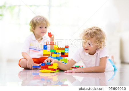 Child playing with toy blocks. Kids play. 95604010