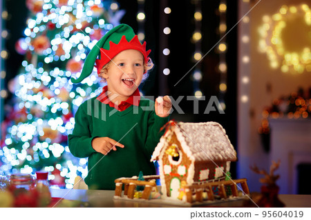 Kids baking gingerbread house. Christmas at home. 95604019