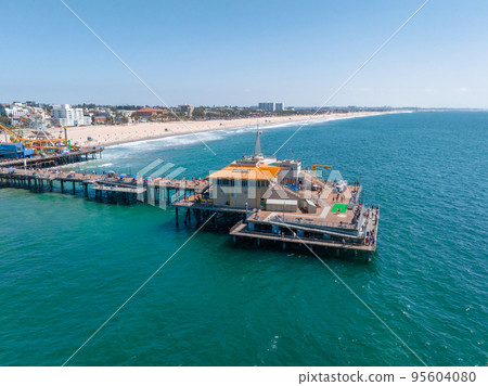 Famous Santa Monica ferris wheel amusement park in sunset light. Panoramic view of the Santa Monica Beach and the Pier Famous Santa Monica ferris wheel amusement park in sunset light. Panoramic view of the Santa Monica Beach and the Pier 95604080