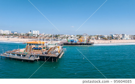 Famous Santa Monica ferris wheel amusement park in sunset light. Panoramic view of the Santa Monica Beach and the Pier Famous Santa Monica ferris wheel amusement park in sunset light. Panoramic view of the Santa Monica Beach and the Pier 95604085