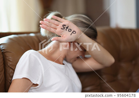 Woman showing palm with stop lettering, protesting against domestic violence Woman showing palm with stop lettering, protesting against domestic violence 95604178