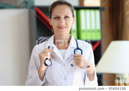 Smiling woman therapist posing in clinic office with stethoscope 95604186