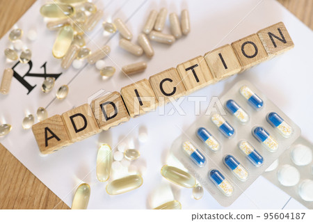 Word addiction collected with wooden cubes on white paper with medicines Word addiction collected with wooden cubes on white paper with medicines 95604187