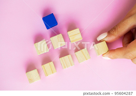 Woman hand arranging empty wood block and copy space on pink background 95604287