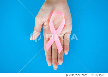 Close up of woman showing pink ribbon symbolizing breast cancer 95604506
