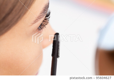 Beautiful smile young woman doing make up in her bathroom. Beautiful smile young woman doing make up in her bathroom. 95604627