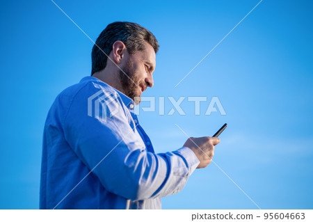 cheerful man chat on smartphone with message. man chatting on phone messaging. cheerful man chat on smartphone with message. man chatting on phone messaging. 95604663