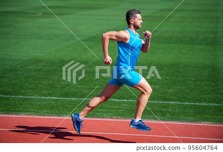 Athletic mature man running on stadium, speed 95604764