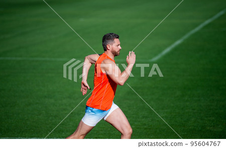 athletic muscular man running on racetrack at outdoor stadium, success athletic muscular man running on racetrack at outdoor stadium, success 95604767