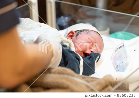 A newborn baby to be dressed (0 days after birth, delivery room) A newborn baby to be dressed (0 days after birth, delivery room) 95605235