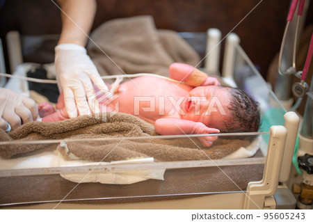 A newborn baby being cleaned (0 days after birth, delivery room) A newborn baby being cleaned (0 days after birth, delivery room) 95605243