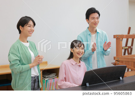Nursery teacher man and woman singing while playing the piano 2 Nursery teacher man and woman singing while playing the piano 2 95605863