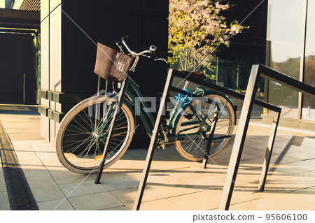 Modern bicycle parked on city street. Business centre district. Exterior design. Vintage ladies cruiser bicycle parked on downtown. Female bike in modern architecture 95606100