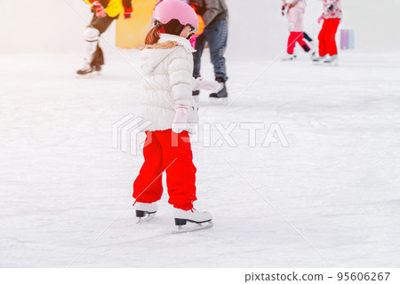 Soft,Selective focus.Adorable little kisd in winter clothes with protections skating on ice rink.A kid 3-5 years old, learn train, ride winter city rink, ice skating.Outdoor.Winter sport. Soft,Selective focus.Adorable little kisd in winter clothes with protections skating on ice rink.A kid 3-5 years old, learn train, ride winter city rink, ice skating.Outdoor.Winter sport. 95606267