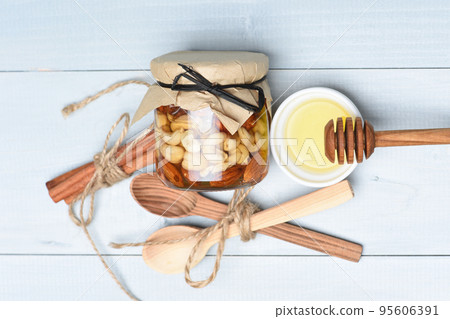 Jar nuts with honey spoons 95606391
