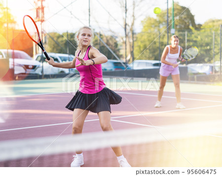Girl playing tennis match during training on court 95606475