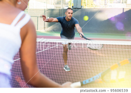 Focused young man playing friendly tennis match. Concept of concentration in competition Focused young man playing friendly tennis match. Concept of concentration in competition 95606539
