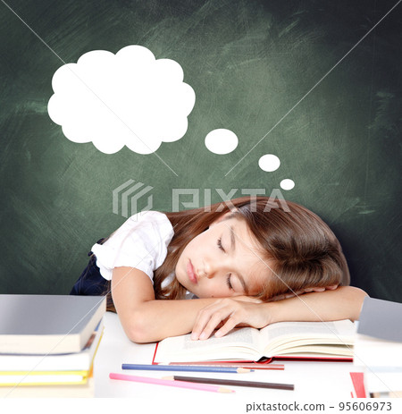 Tired little child girl sleeping on the desk at school. 95606973