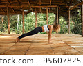 Woman Practicing Yoga in Tropical Open Yoga Studio place 95607825