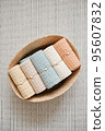 Collection of natural muslin bath towels in a wicker basket on the floor. Natural, soft, air and stylish home textiles. 95607832