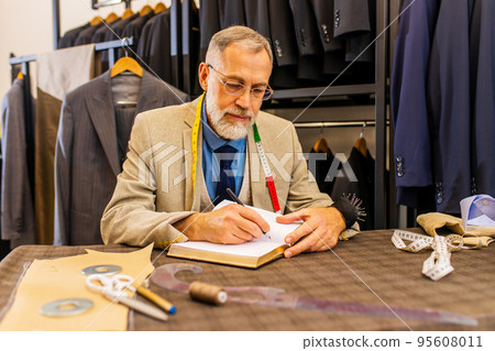 well-dressed bearded mature handsome man working in his atelier studio well-dressed bearded mature handsome man working in his atelier studio 95608011