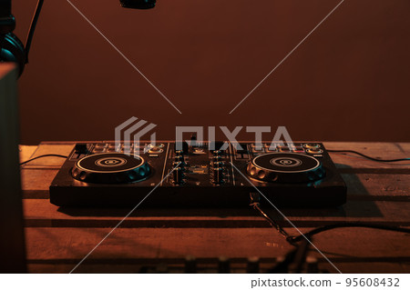 Empty table with stereo turntables and dj equipment, audio instrument with microphone and headphones. Electric vinyl used at nightclub or party to mix and listen to techno music, electronics. 95608432