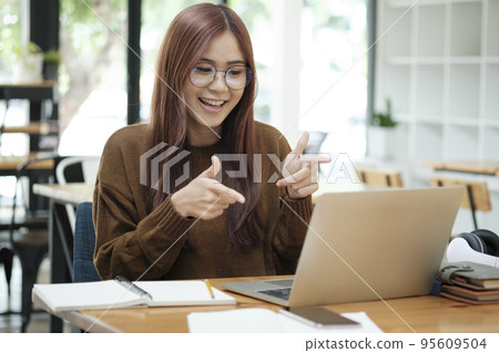 Young asian female student learning online using laptop. 95609504