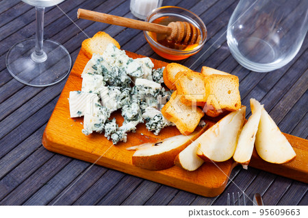 Roncari blue cheese with pear, toasts and honey on wooden board Roncari blue cheese with pear, toasts and honey on wooden board 95609663