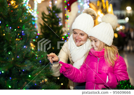 Friendly family of mother and daughter having fun on outdoor fair Friendly family of mother and daughter having fun on outdoor fair 95609666
