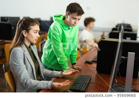 Teacher shows the student how to solve the problem on computer Teacher shows the student how to solve the problem on computer 95609668