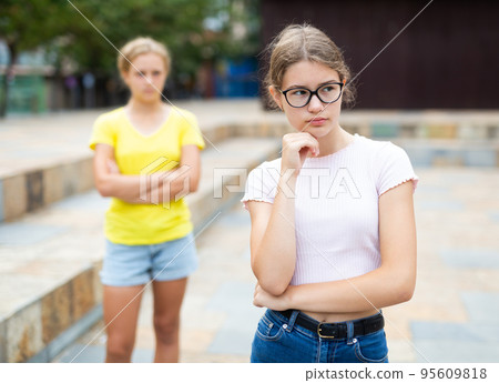 Youth girls quarreling between each other outdoors Youth girls quarreling between each other outdoors 95609818
