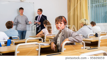 Teenage girl sitting at desk in classroom Teenage girl sitting at desk in classroom 95609859