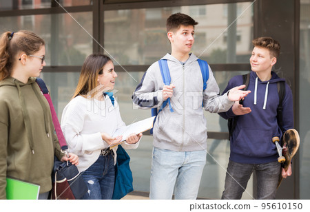 Carefree teen students walking outside school Carefree teen students walking outside school 95610150