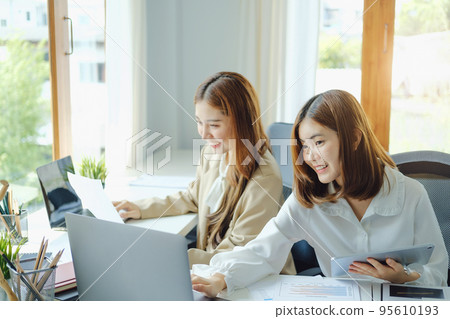 Negotiation, Analysis, Discussion, Portrait of an Asian woman economist and marketer using computer laptop to plan investments and financial to prevent risks and losses for the company. 95610193