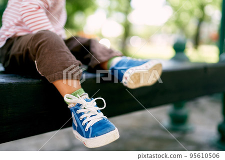 Little baby feet in blue sneakers. Close-up. High quality photo Little baby feet in blue sneakers. Close-up. High quality photo 95610506