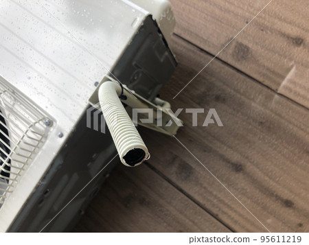 Air conditioner drain hose with water droplets Air conditioner drain hose with water droplets 95611219