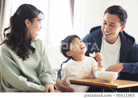 Smiling family sitting on the sofa 95611905