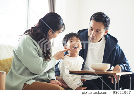 Smiling family sitting on the sofa 95611907