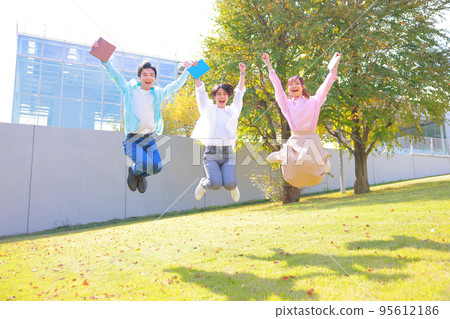 College student men and women jumping on campus 4 95612186