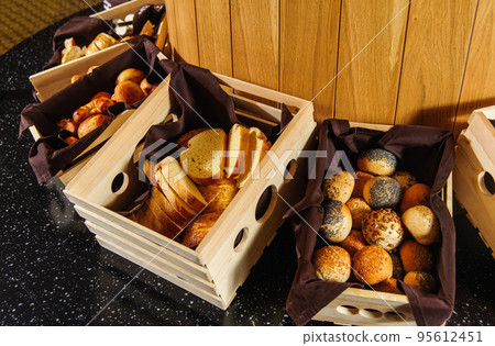 A buffet table with variety of bread in the wooden baskets 95612451