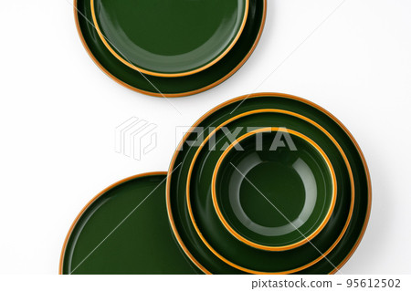 A set of green ceramic plates and bowl on a white background. Top view A set of green ceramic plates and bowl on a white background. Top view 95612502