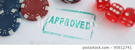 Stamp approved standing near playing cards and chips in casino with dice 95612741